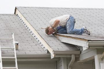 Contractor Repairing Roof Leak With Sealant