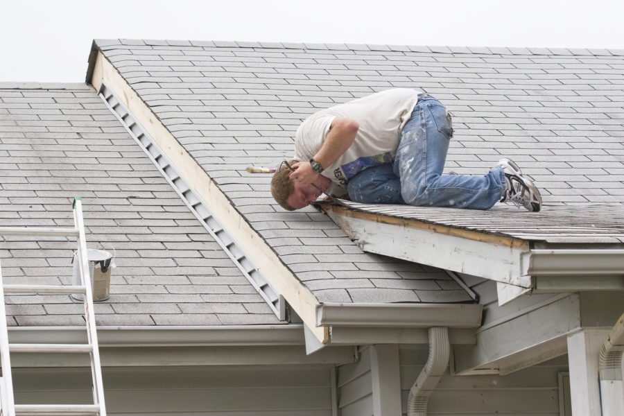 Contractor Repairing Roof Leak With Sealant