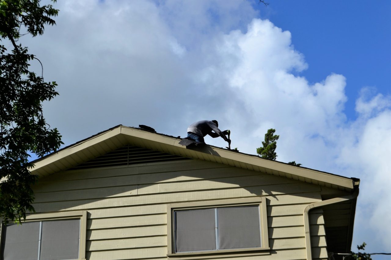 Roofer At Work Stripping Old Roof